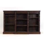 A Victorian and later carved oak breakfront bookcase on a plinth base, l.