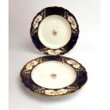 A pair of Derby-style shallow bowls decorated with floral sprays within a blue border, d. 25.