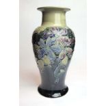 A Royal Doulton vase of baluster form relief decorated with stylised flowers on a mottled green