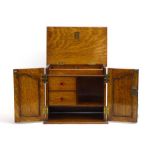 A 1920/30's oak smoker's cabinet, the two doors enclosing a fitted interior, w.