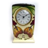 A modern Moorcroft timepiece of rectangular form, decorated with stylised lilies on a cream ground,