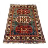 A late 20th century woolen rug with a red ground, repeating motifs and matching bands,
