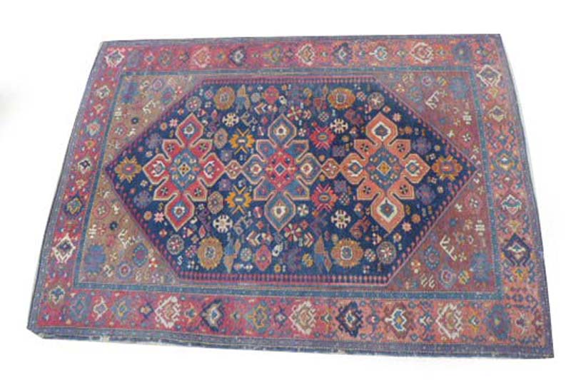 An early 20th century rug, the three medallions within a red and blue ground and matching borders,