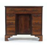 A George II-type mahogany kneehole desk with an arrangement of one long and six short drawers and a