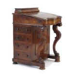 A Victorian figured walnut davenport with a tooled leather surface, four drawers,