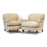 A pair of Recline & Sprawl low open lounge armchairs upholstered in a cream fabric with repeated