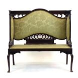 An Edwardian mahogany and upholstered settle