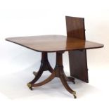 A 19th century mahogany twin-pedestal dining table, with one fitted leaf,