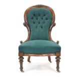 A Victorian mahogany and button upholstered nursing chair on turned front legs with castors