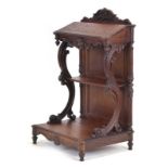 A Victorian oak and carved prie dieu with scrolled supports and a decorative apron,