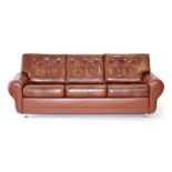 A 1970's Danish three seater sofa upholstered in cognac brown button upholstery on chrome feet