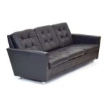 A late 1960's/early 1970's black button upholstered three-seater sofa in the manner of Skippers