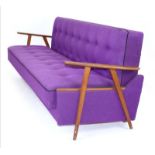 A 1960's Danish daybed with teak arms and purple woolen button upholstery