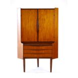 A 1960's Danish teak corner cabinet, the pair of doors enclosing adjustable shelves,