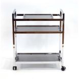 Howard Miller, a 1970's polished steel and glass three-tier cocktail trolley on castors, w.