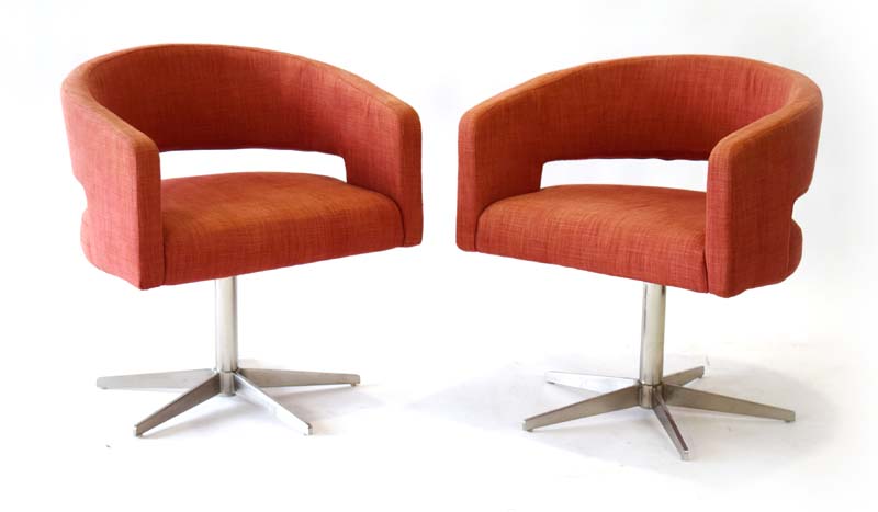 A pair of contemporary Swedish swivel chairs upholstered in pale red cotton on metal five-star