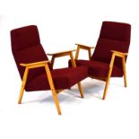A pair of 1950's Czech beech framed and red upholstered armchairs on tapering legs,