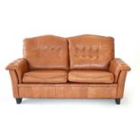 A 1970's Danish tan leather and button upholstered two seater sofa with stitched detail