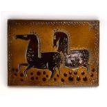 An Upsala Ekeby wall plaque relief decorated with two stylised horses on a mustard ground,