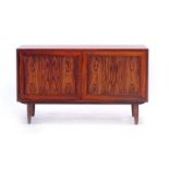 A 1960's Danish rosewood panelled two-door cabinet on turned beech legs, w.