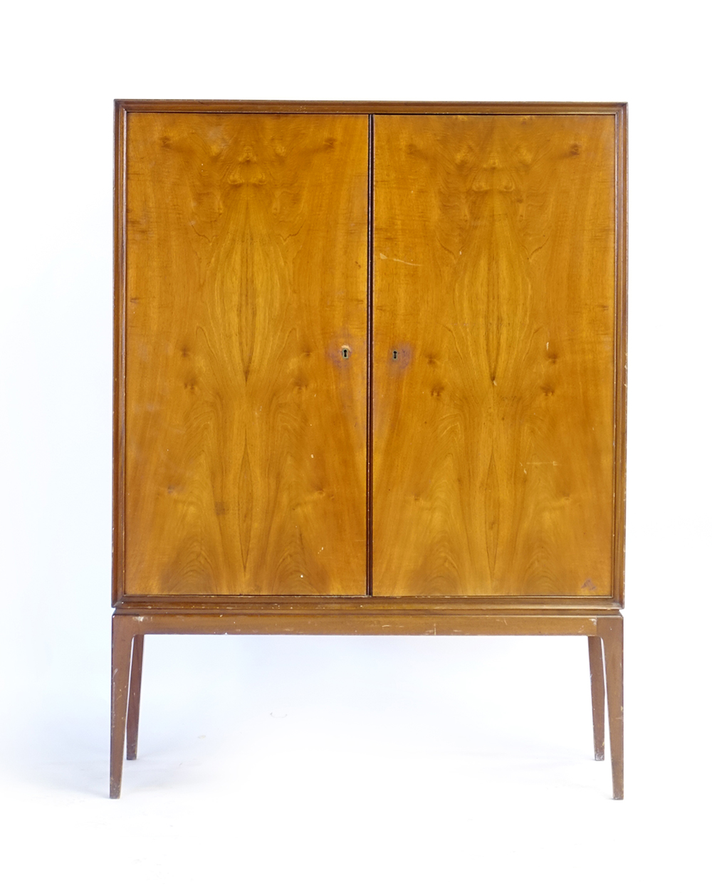 A 1960's walnut finished cabinet, the two doors enclosing shelves and trays,