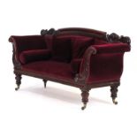 A 19th century and later mahogany sofa of Rococo form on turned legs with castors