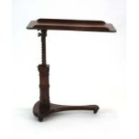 A Victorian mahogany adjustable reading table on a turned shaft and platform base,