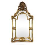 A 20th century wall mirror with a moulded gilt frame and shell pediment,