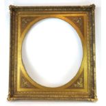 A 20th century oval mirror frame with a rectangular gilt border,