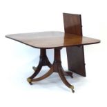 A 19th century mahogany twin-pedestal dining table, with one fitted leaf,