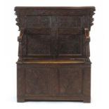 An 18th century-type carved oak and panelled monk's bench,