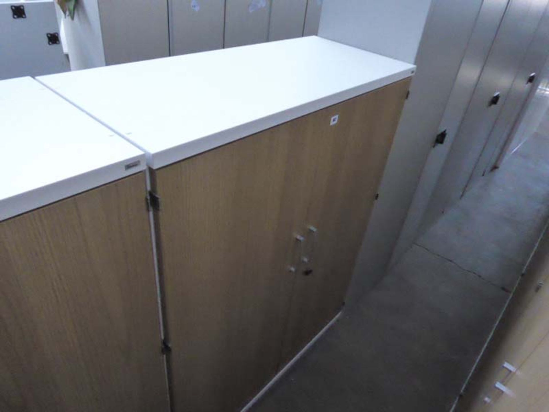 A 100cm wide by 134cm high Kinnarps white and oak effect 2 door stationary cupboard