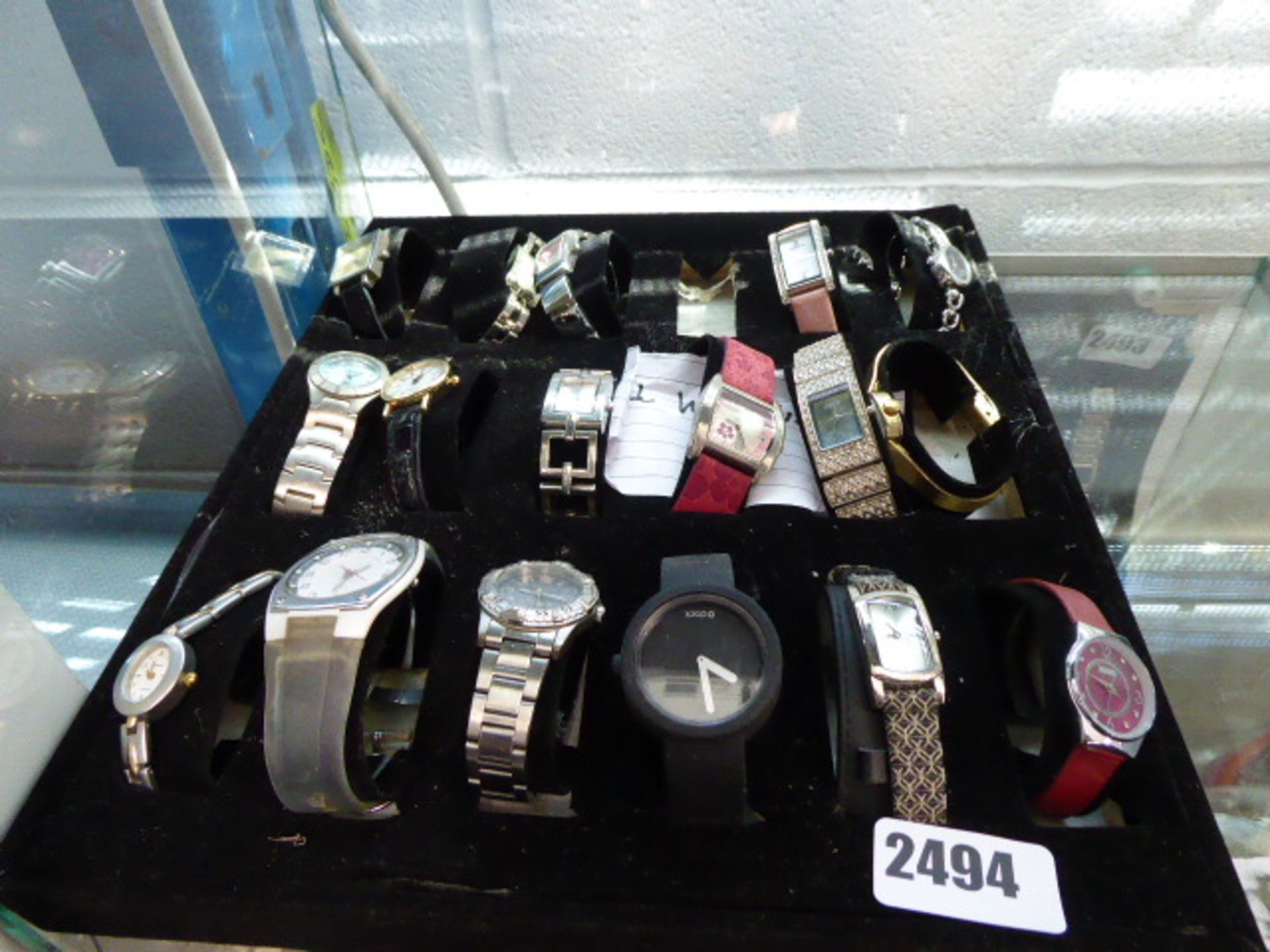 A black cloth tray containing various loose wristwatches