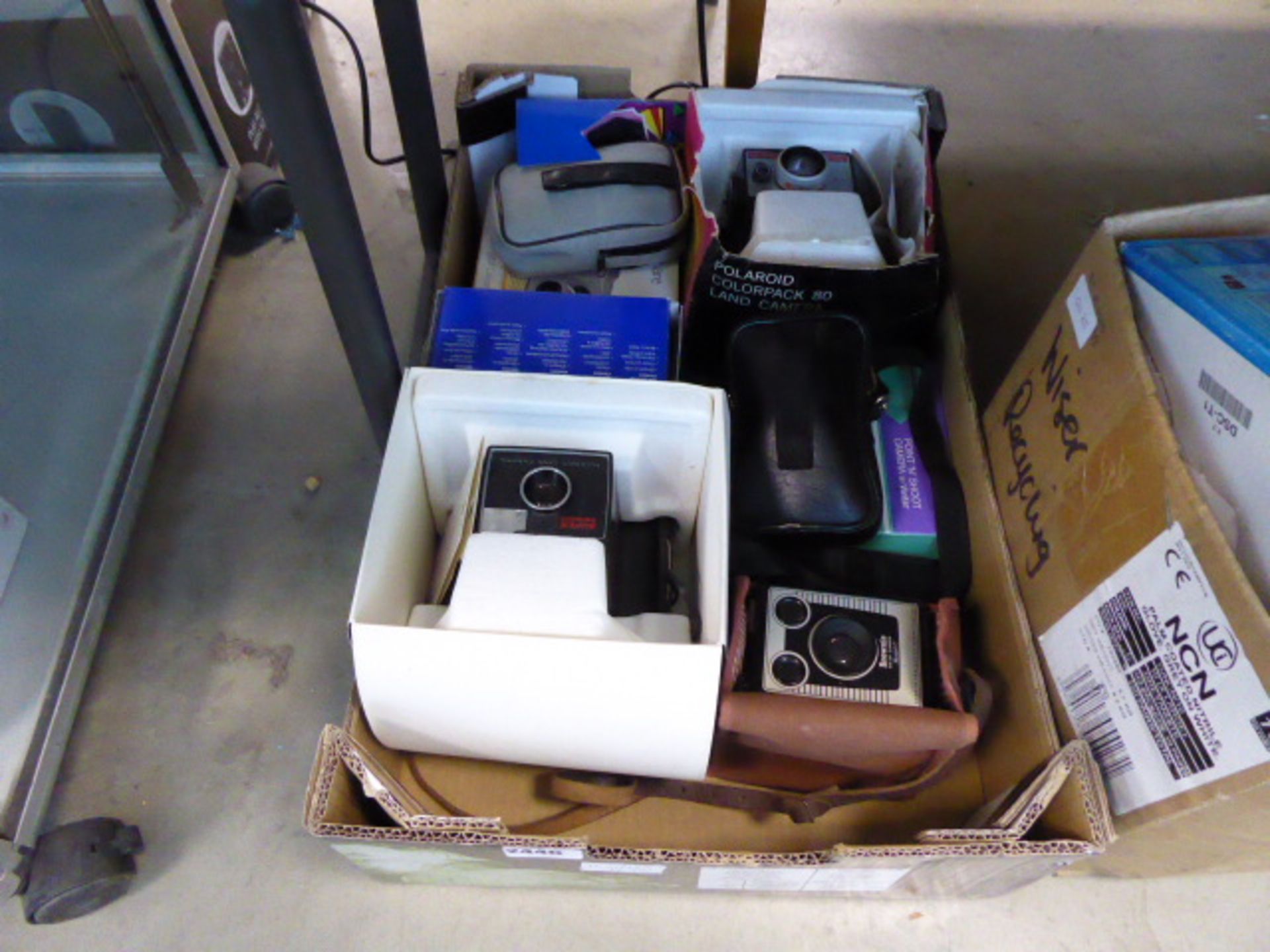 A selection of vintage film camera equipment including Polaroid Swing cameras