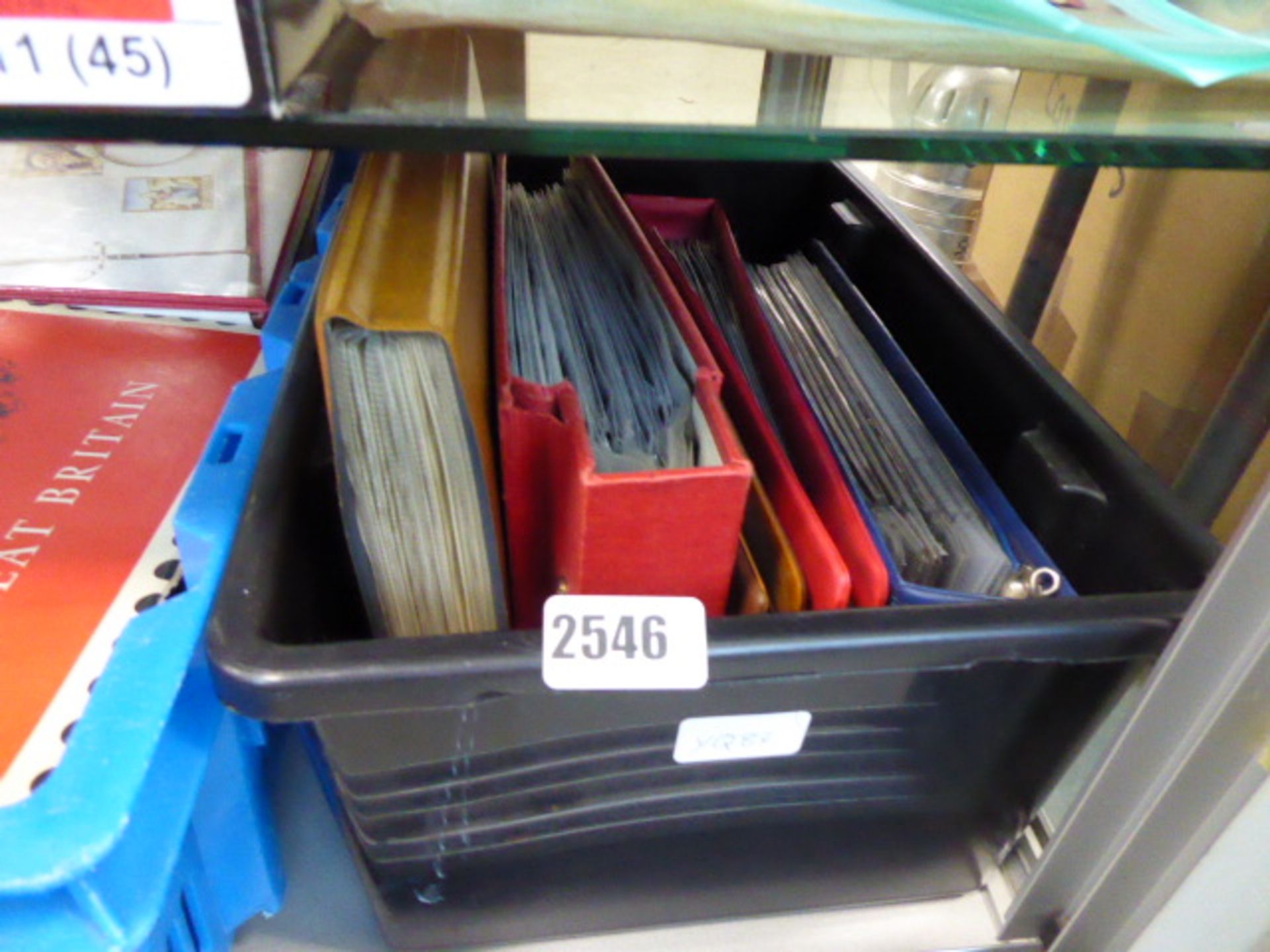 A crate containing various first day cover albums and contents