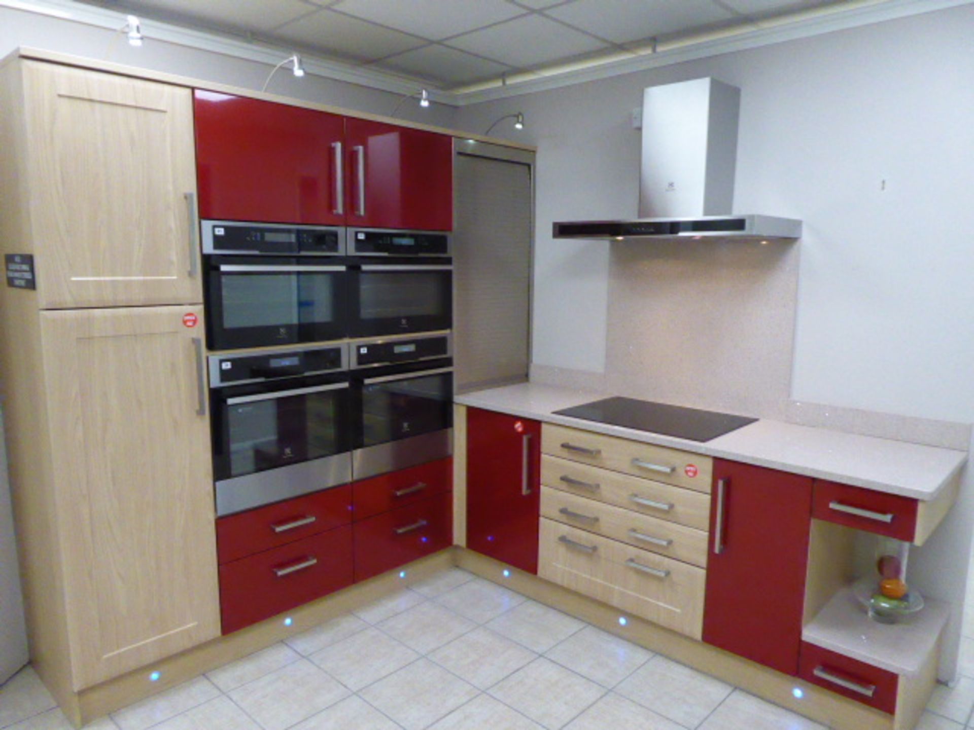 Alto gloss red China and York Shaker Corsico chestnut L-shape kitchen with quartz worktops. Max