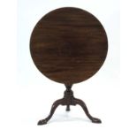 A Georgian mahogany tilt-top table, the circular surface on a turned column and tripod base, d.