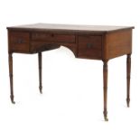 A 19th century knee-hole dressing table/desk with three frieze drawers, on turned legs with castors,