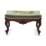 A 19th century mahogany and upholstered stool with a shaped and moulded apron,