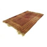 A Bokhara red woolen carpet, the centre with repeated medallians, within matching borders,