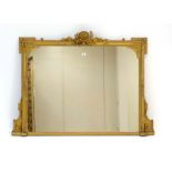 A 19th century giltwood overmantle mirror surmounted by a shell and bow pediment,