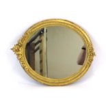 A 19th century giltwood wall mirror, the oval plate surmounted by fruiting vines,