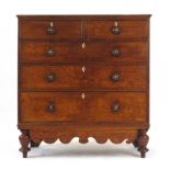 A 19th century oak chest of two short over three long graduated drawers and a shaped apron on