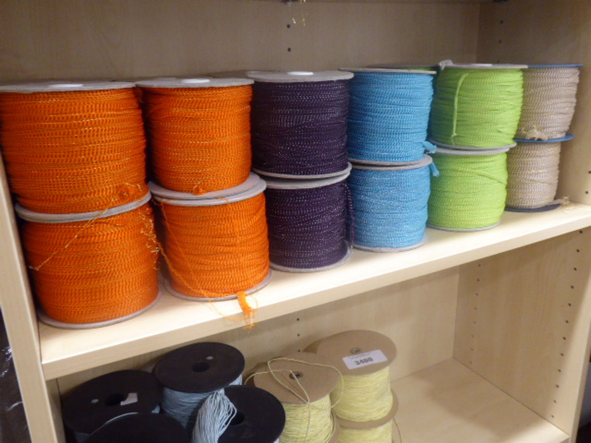 24 reels of sewing braids in green, blue, mauve, and orange