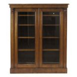 A Victorian walnut bookcase with two glazed doors, on a plinth base, w.