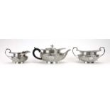 A late Victorian three piece silver tea service with leaf capped handles and foliate decoration,