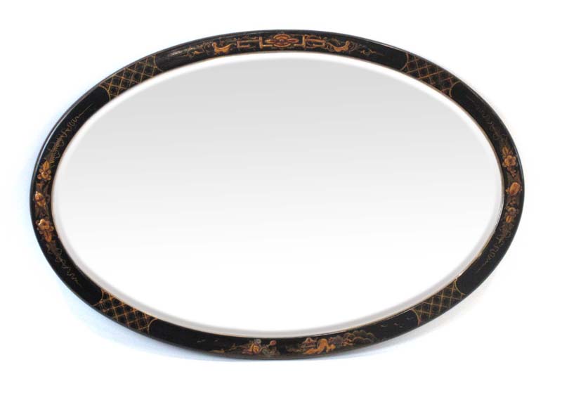 A black lacquered oval bevelled mirror decorated in the chinoiserie manner,