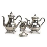 A Peruvian metalware three piece tea service of vase shaped form in the rococo manner,