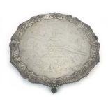 An Edwardian silver salver of circular form with gadrooned foliate border on four claw and ball