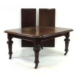 A 19th century mahogany extending dining table with two fitted leaves on turned legs with castors,